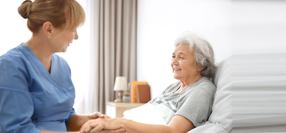 Soins à domicile : Un soignant auprès d'un patient atteint d'un cancer